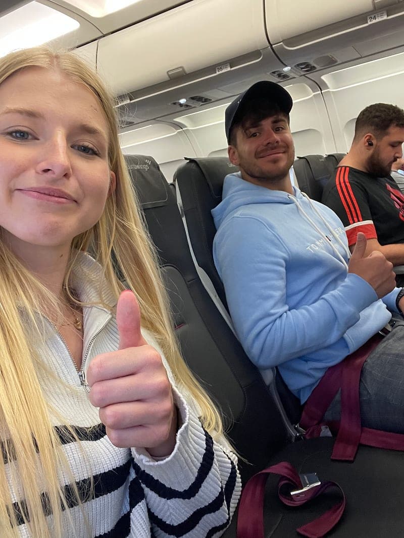 Miriam und Hendrik im Flugzeug, Miriam hält den Daumen hoch